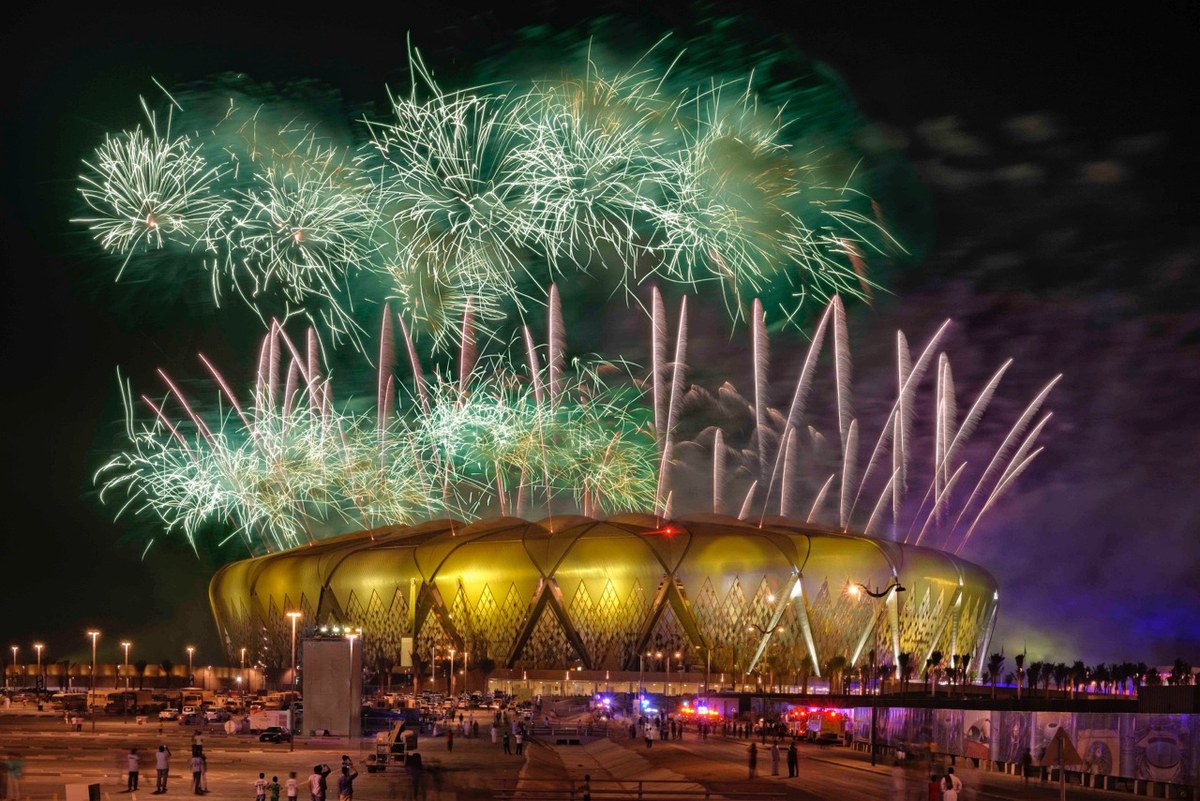Fireworks bursting over the illuminated stadium on an event night