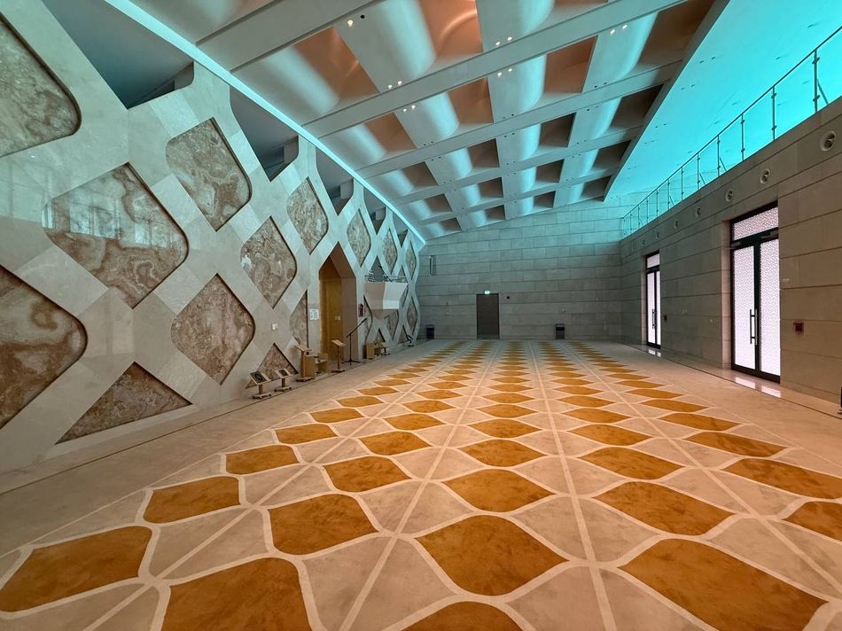 Prayer rows marked across the hall carpet, facing the mihrab