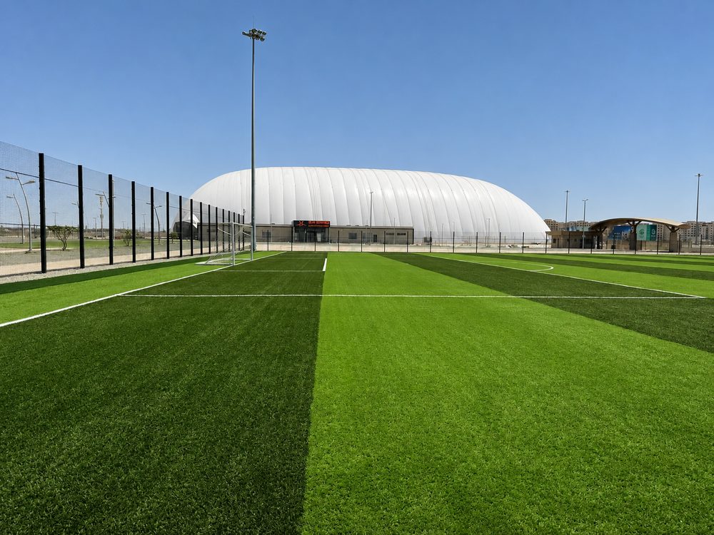 A striped artificial pitch running toward the covered air dome