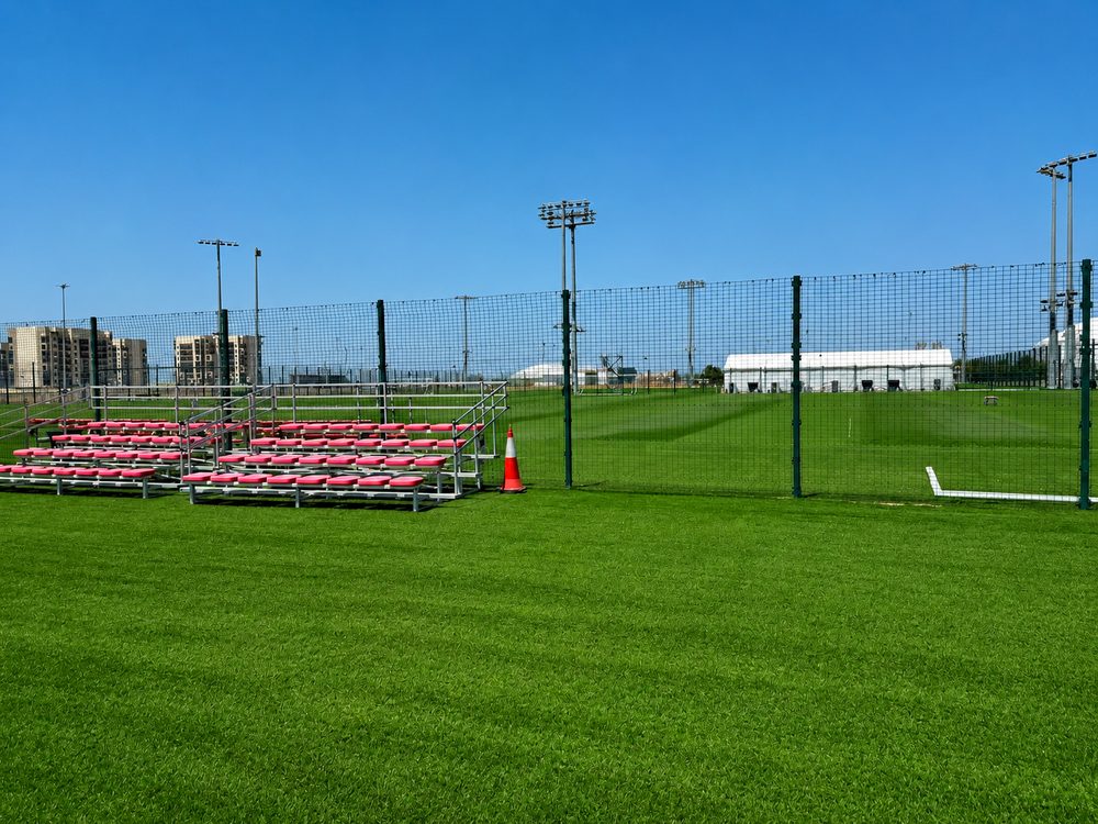 Pitch-side bleachers and goals behind the perimeter fencing