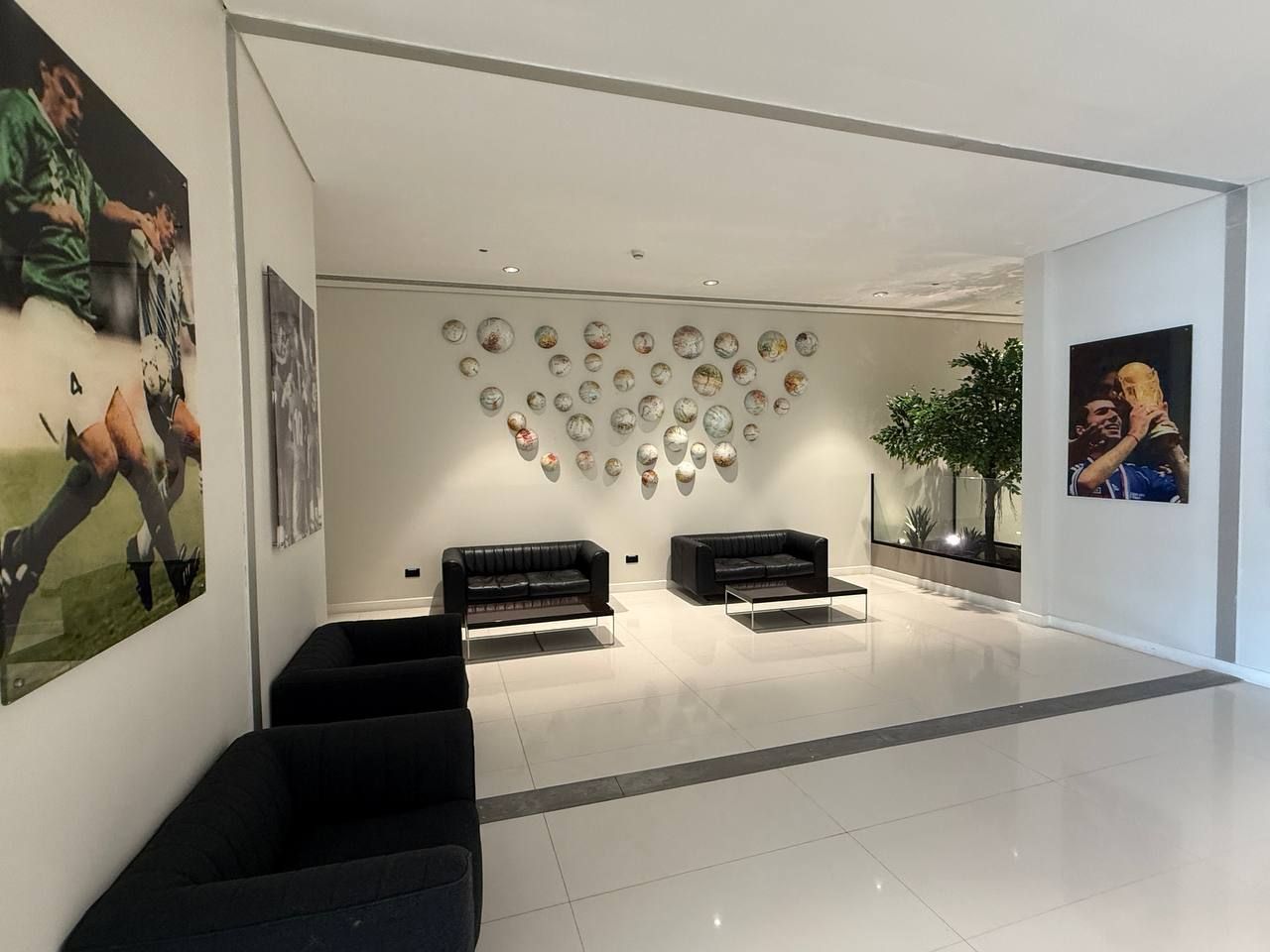 A lounge with leather sofas beneath a wall of decorative plates